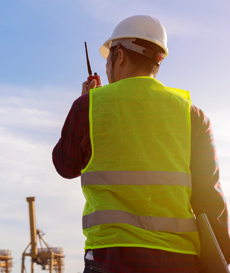 Sicherheitsmitarbeiter mit Funkgerät auf einer Baustelle